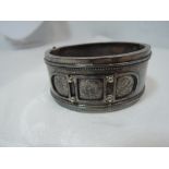 A Victorian white metal hinged cuff bangle having engraved floral decoration in applique panels,