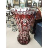 A glass vase of burgundy Bohemian design, cut flask style