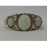 A lady's dress ring having three oval opals interspersed by two pairs of diamonds in a gallery mount
