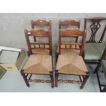 A set of four early 19th century beech vernacular kitchen chairs having bobbin rail backs, with