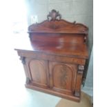 A mid Victorian flame mahogany chiffonier having raised scroll ledge back over frieze drawer and