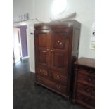 A late 18th century oak cupboard having panel doors over two short and one long drawer on bracket