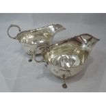 A pair of Edwardian silver sauce boats of traditional form, having moulded scroll rims, loop handles