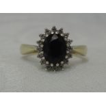A lady's dress ring having an oval sapphire and diamond chip cluster on a 9ct gold loop, size O