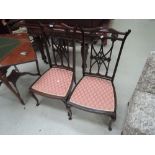A pair of late Victorian mahogany salon chairs having fleur and lattice backs with later pad seats