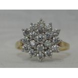 A lady's dress ring having a cubic zirconia triple cluster in a claw set basket mount on a 14ct gold