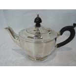 A small silver teapot of facetted circular form having hard wood handle and knop, Birmingham 1927,