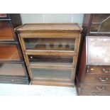 An early 20th century golden oak three tier stacking bookcase