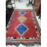 A 20th century rug of Turkish style having red, blue and gold lozenge ground, 230 x 170cm