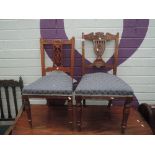 Two late Victorian mahogany salon chairs having carved slat backs with later upholstered seats and