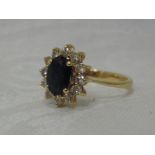 A lady's dress ring having a sapphire and diamond oval cluster in a claw set mount to knife blade