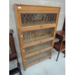 An early 21st century golden oak four tier stacking bookcase having leaded glass panels