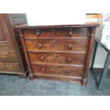 An early 19th century flame mahogany chest of two short and three long drawers, flanked by pillars