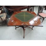 An Edwardian mahogany card table of fold top envelope design having baize interior and shaped legs