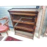 An early 20th century dark oak three tier stacking bookcase