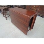 A mid 20th century sapele mahogany dining table having rectangular drop leaf, on chamfered gate