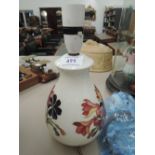 A Moorcroft table lamp having floral decoration on cream ground