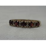 A lady's half eternity ring having garnet and cubic zirconia stones on a 9ct gold loop, size R/S