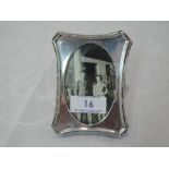 A small silver photograph frame of plain shaped rectangular form having oval aperture and wooden