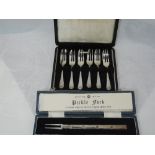 A cased set of six silver cake forks of plain form having floral cascade decoration to terminals,
