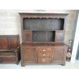 A late 18th/early 19th century oak dresser base having central drawers flanked by cupboards with