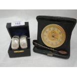 A cased pair of silver napkin rings having foliate engraved decoration and plain cartouches,