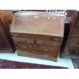 An early 19th century part mahogany bureau having slope front with fitted interior, drawer base