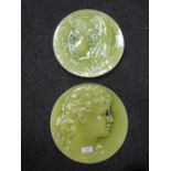A pair of Burmantofts faience plaques, modelled as ladies in profile, signed P Mallet