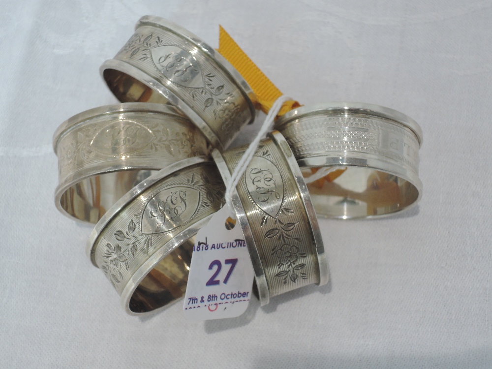 A set of four Edwardian silver napkin rings having engraved floral decoration and monogrammed