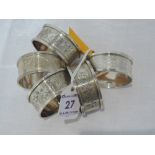 A set of four Edwardian silver napkin rings having engraved floral decoration and monogrammed