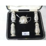 A cased five piece silver condiment set having facetted decoration and blue glass liner,