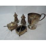 A silver four piece cruet set of plain form having shaped rims, glass liners and paw feet,