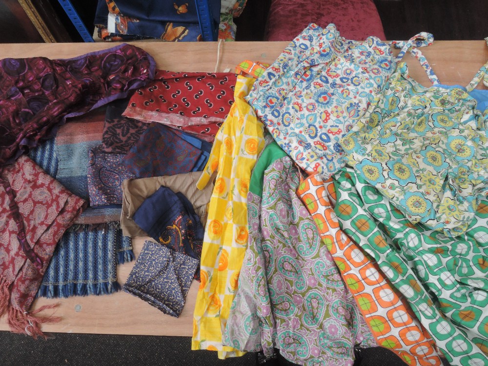Selection of cheerful vintage aprons, some headscarves and neck scarves. Predominantly 1950s.