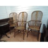 Three near matching beech and elm vernacular Windsor armchairs having solid seats and turned legs