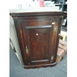 An early 19th century oak corner wall cupboard having panel doors