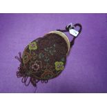 Antique beaded handbag having clasp fastening, fringing to bottom and floral pattern.