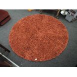 A red shag pile circular rug