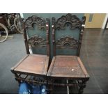 A pair of late Victorian oak carolean style hall chairs having carved moon face and cloud rail