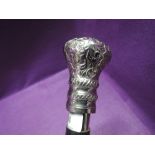 An Indian style wooden walking stick having a white metal moulded knop and inset brass decoration,