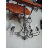 A large wrought iron style 12 tier candelabra light fitting
