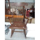 A traditional stained frame rocking armchair