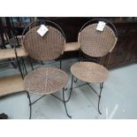 A pair of modern metal and wicker garden chairs