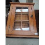 A stripped pine glazed wall cabinet