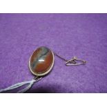 A moss agate brooch/pendant in a 9ct gold mount having rope wire decoration, with safety chain
