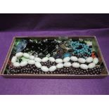 A selection of costume jewellery including long string of coloured Joan Rivers pearls, eye glass,
