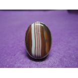 A lady's dress ring having a large striped oval orange agate in a collared mount on an HM silver