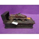 A vintage cast iron money box in the form of a race car