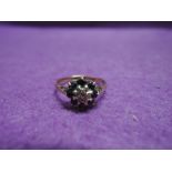 A lady's dress ring having a sapphire and diamond cluster in a claw set n=mount on a 9ct gold