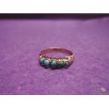 A lady's dress ring having five turquoise style stones in a gallery mount on a 9ct gold loop, size