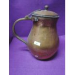 A large hand beaten copper and brass handle water jug